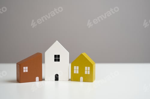 Preview: House figurines on a gray background. Buying and selling.