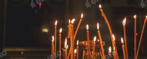 Preview: Lit candles burn brightly in an orthodox church setting