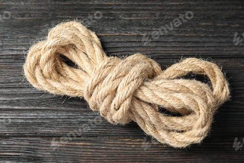 Preview: Bundle of natural hemp rope on wooden background, closeup