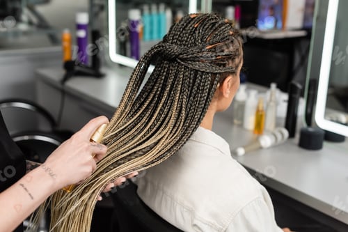 Preview: hair salon, tattooed hairdresser applying hair product on braids of woman in salon, spray bottle,