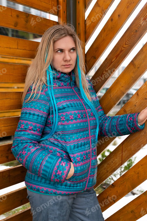 Preview: Cute young woman with a colored strand in her hair walks in winter