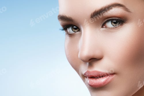 Preview: Young woman with natural makeup and smooth skin against light blue background