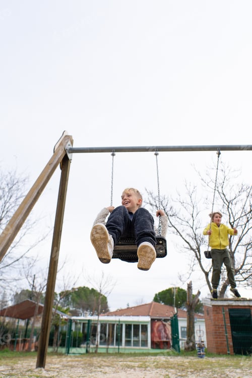 Preview: Children swinging on a swing in a playground