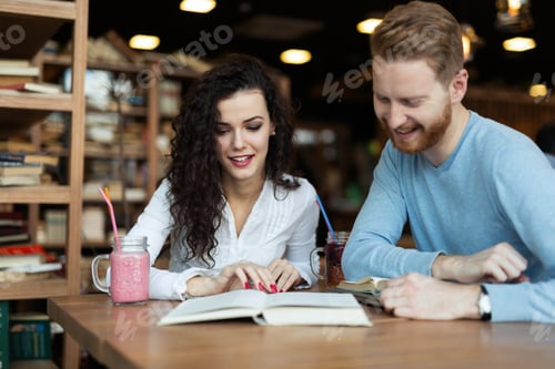 Preview: Young students spending time in coffee shop reading books