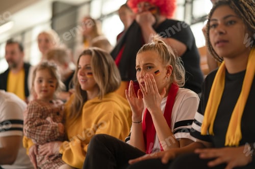 Preview: Worried football fans supproting German national team in live soccer match at stadium.