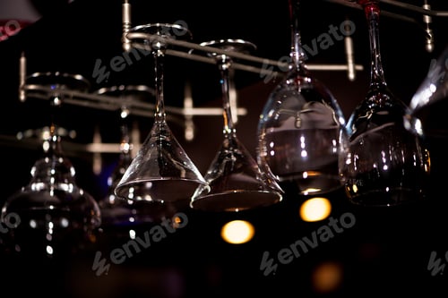 Preview: Empty glasses for wine above a bar rack