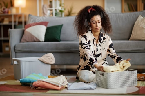 Preview: African American woman folding clothes