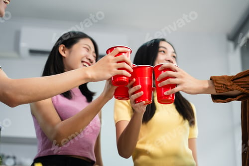 Preview: Young Asian students gather with friends for a pizza party, laughing and sharing slices.