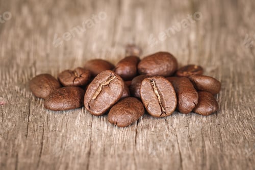 Preview: pile of roasted coffee beans on wood desk with selective focus