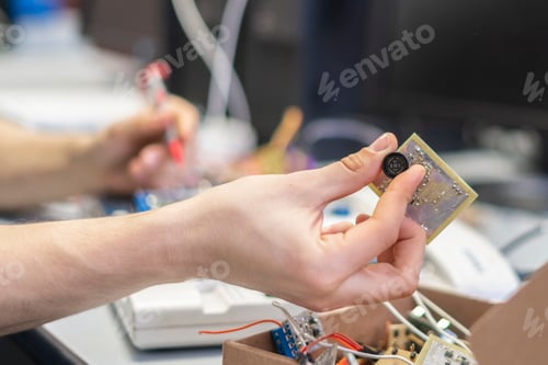 Preview: engineer hold circuit or silicon chip in his workplace b