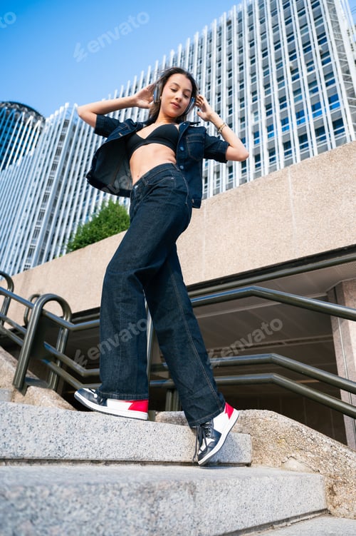 Preview: Young woman enjoying music on urban stairs
