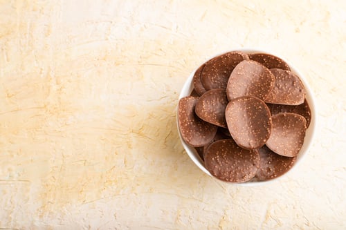 Preview: Chocolate chips on a beige concrete background. top view, copy space.