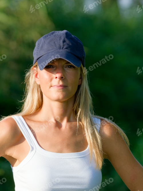 Preview: Woman in white tank top wearing a blue baseball cap outdoors, Italy