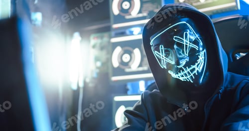 Visualização: A hacker wearing a mask to cover his face is using computer to hack data to get ransom from victims.
