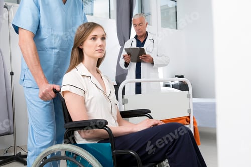 Preview: Doctor in hospital pushing woman in wheelchair