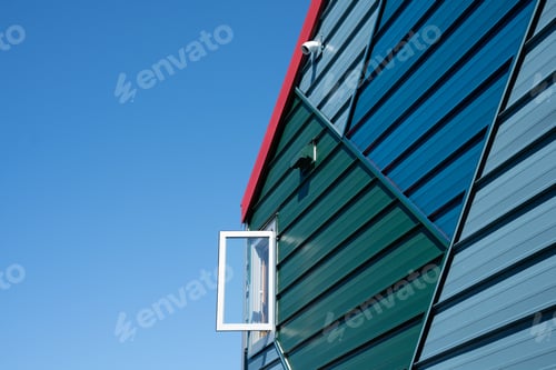 Preview: Closeup of a house exterior in blue tones with a skyscape in the background