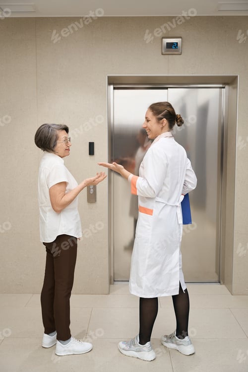 Preview: Two women are standing by elevator in lobby of clinic