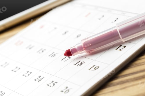 Preview: Highlighting important dates on a calendar using a pink marker in a workspace setting
