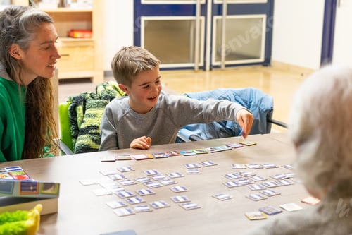 Preview: Family playing a board game together in a nursing home with their grandmother
