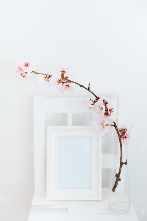 Preview: Almond blossom twigs with picture frame mockup. White background, copy space.