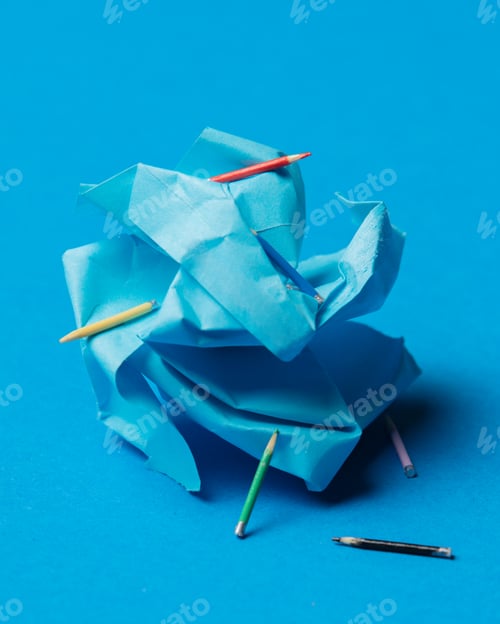 Preview: crumpled paper and pencils on blue background