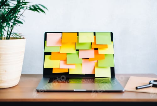 Preview: Workplace with laptop computer with many colorful empty sticky notes on display.