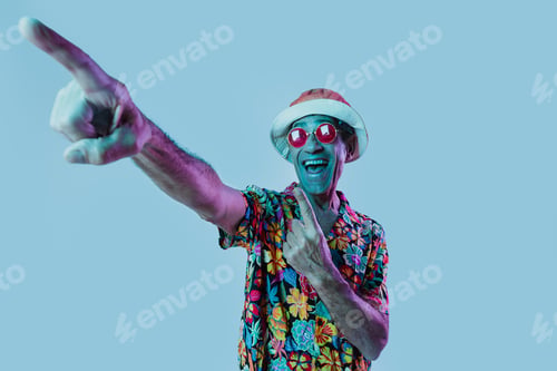 Preview: Senior man posing in studio under colored gel lights.