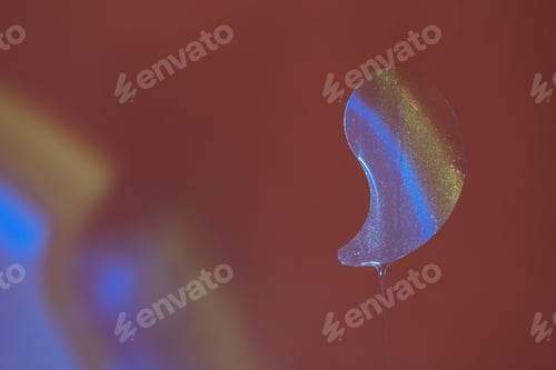 Preview: Transparent eye patches with serum hanging against a red background