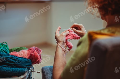 Preview: Hands of senior woman knitting at home
