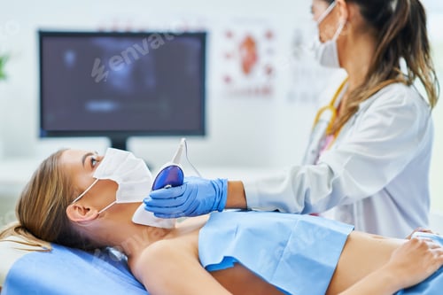 Preview: Doctor in mask checking thyroid to her female patient