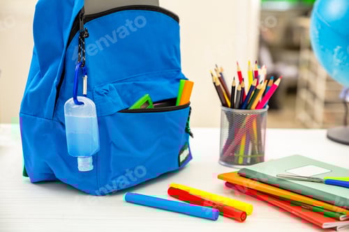 Visualização: Escola, dias de coronavírus. Proteção COVID 19, gel desinfetante para as mãos e mochila na mesa do estudante