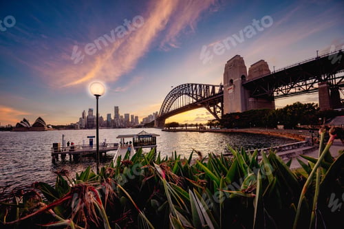 Preview: Bridge crossing a body of water at sunset in Sydney, Australia.