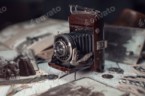 Preview: Vintage film camera on the table among old family photos.
