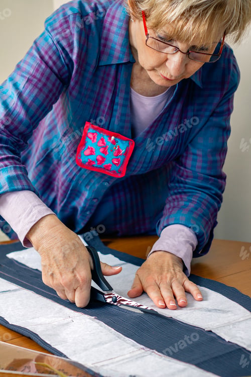 Preview: Dressmaker cutting a cloth