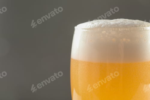 Preview: Glass of tasty beer with foam on color background, closeup
