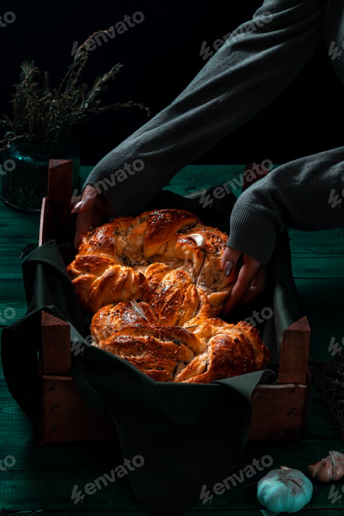 Preview: Freshly made Italian bread on greenwooden board with herbs and garlic, Mediterranean Food background