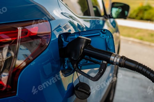Blue Car Refueling at Gas Station Pump