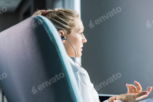 Preview: Woman sitting on couch with earphones