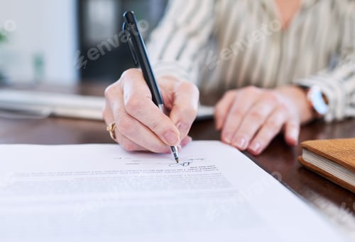Preview: Closeup shot of an unrecognisable businesswoman signing paperwork in an office
