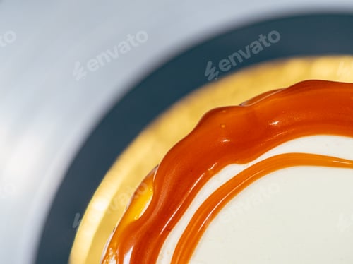 Preview: baker chef decorating cup cakes with cream and salty caramel using black gloves
