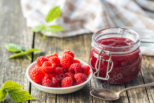 Preview: Red rasberries jam in jar and ripe raspberries.