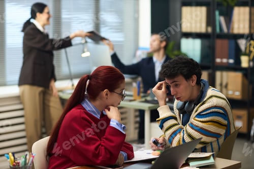 Preview: Young Woman and Young Man Discussing Work in Modern Office Setting
