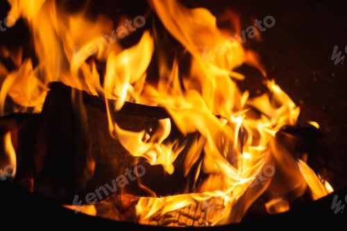 Preview: close-up flames on log in blur. background with Burning firewood in fireplace, selective focus.