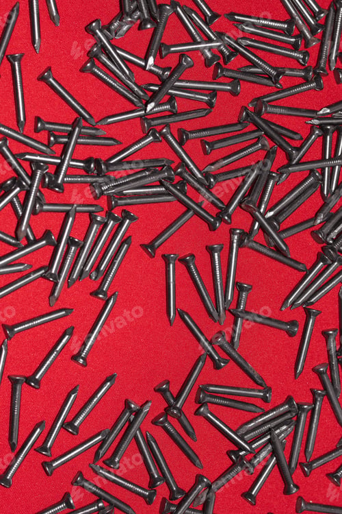 Preview: Black steel nails on red background, randomly scattered
