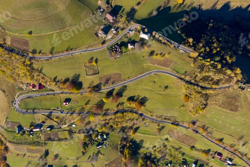 Preview: Aerial view of epic countryside road and autumn forest from above, drone point of view