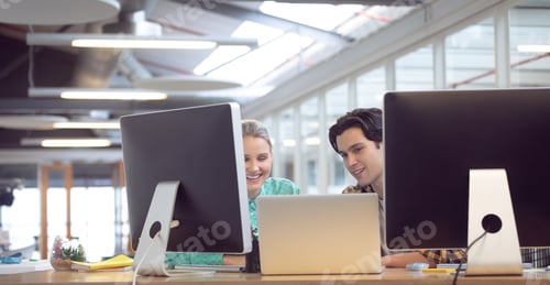 Preview: Front view of Caucasian male and female graphic designer discussing over computer at desk in office