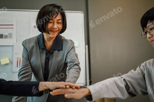 Preview: Businesspeople stacking hands together at meeting table. Concept of corporate unity and solidarity