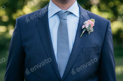 Preview: a man in a dark suit and tie wears a flower button up