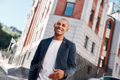 Preview: Outdoors leisure. Young man walking on the city street smiling cheerful