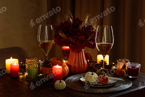 Preview: Thanksgiving table setting with decorative pumpkins, candles and string lights on dark wooden table